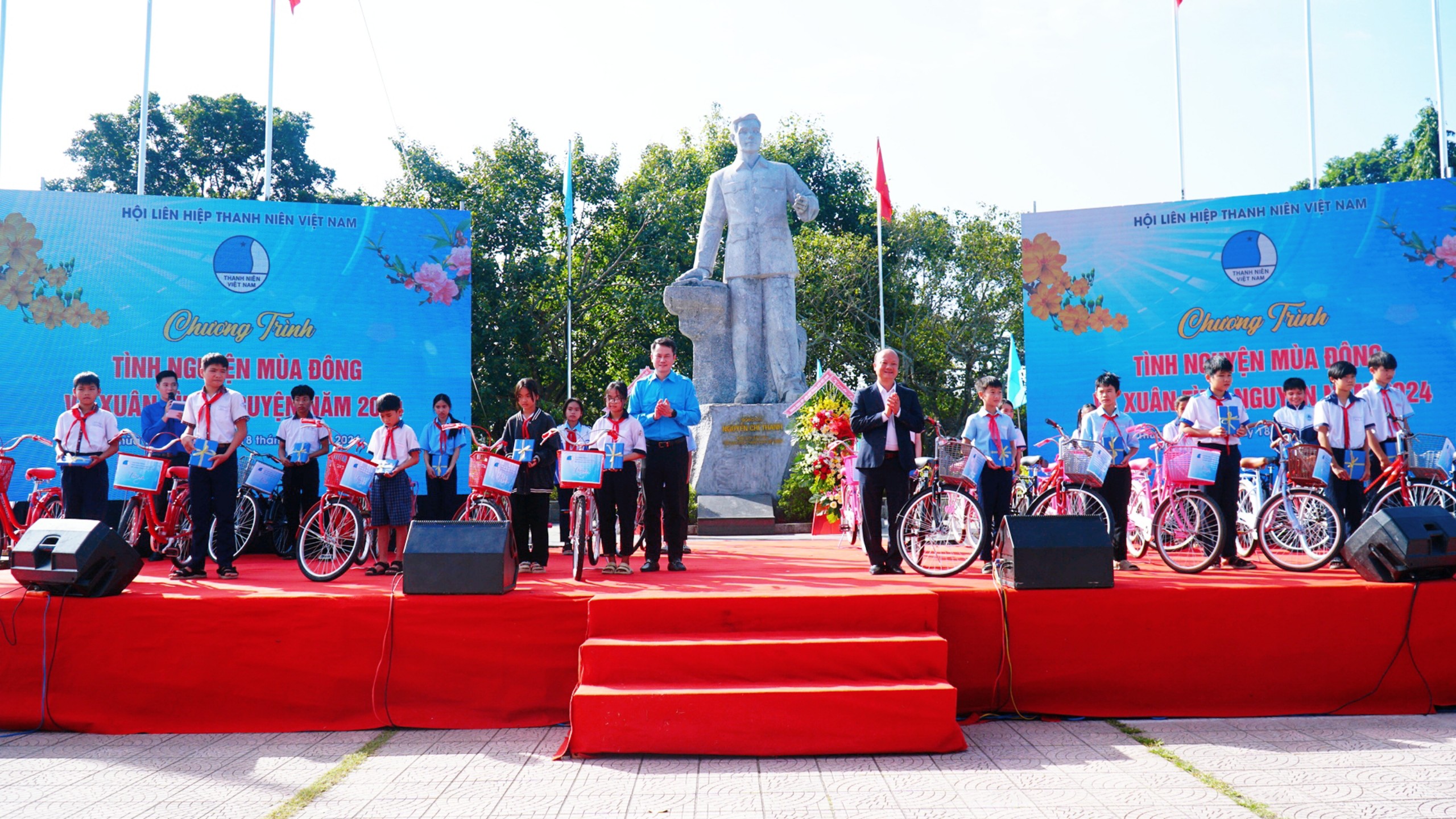 Anh Nguyễn Kim Quy, Phó Chủ tịch thường trực Hội LHTN Việt Nam (áo xanh, hàng đầu) và anh Nguyễn Hồng Phong, Phó Chủ tịch Hội Doanh nhân trẻ Việt Nam (áo vest đen) trao tặng xe đạp cho các em học sinh tại tỉnh Thừa Thiên - Huế.